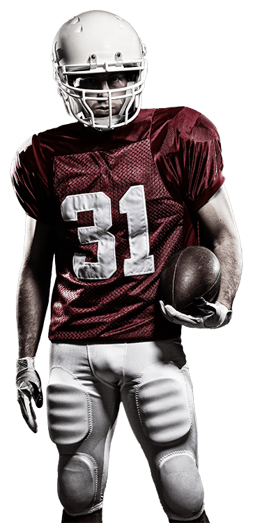 Photo of a football player posing with a football in his left hand looking at the camera
