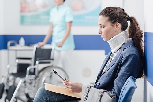 Woman with Neck Injury sitting in a hospital waiting to be seen