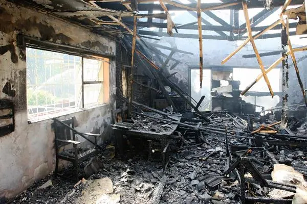 Photo from a inside a partially burned down house with the roof mostly missing