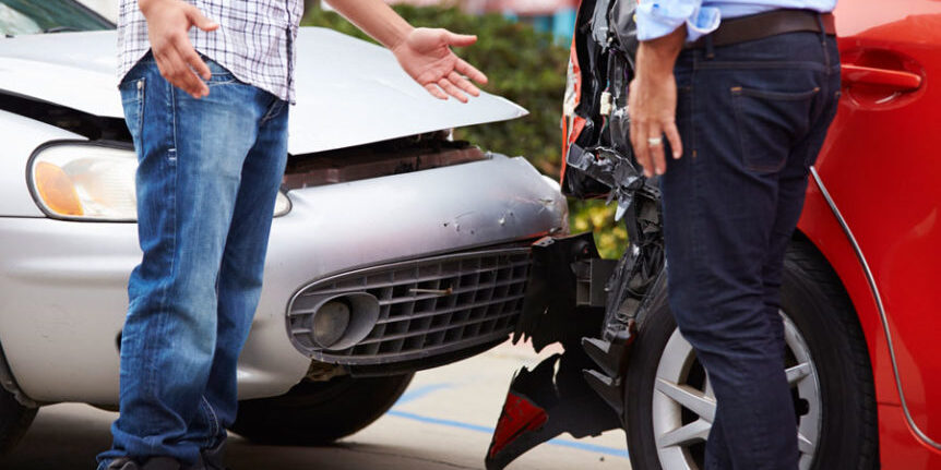 Photo of a rear ending car accident with two people in front of the accident