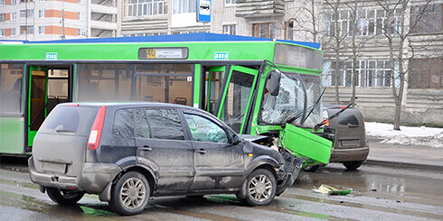 Photo of a car and bus in the middle of the road after a head on collision