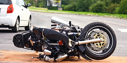 Photo of a motorcycle damaged on its side in the middle of the road
