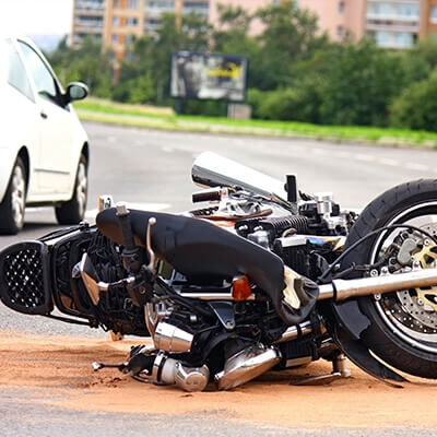 Photo of a motorcycle damaged on its side in the middle of the road