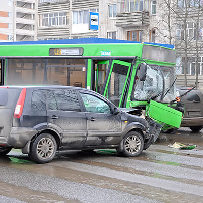 Photo of a car and bus in the middle of the road after a head on collision