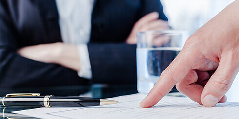 Photo of of someone pointing at a clause in a premise liability contract